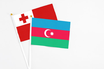 Azerbaijan and Tonga stick flags on white background. High quality fabric, miniature national flag. Peaceful global concept.White floor for copy space.