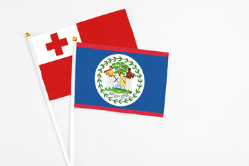 Belize and Tonga stick flags on white background. High quality fabric, miniature national flag. Peaceful global concept.White floor for copy space.