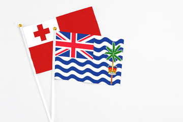 Fototapeta premium British Indian Ocean Territory and Tonga stick flags on white background. High quality fabric, miniature national flag. Peaceful global concept.White floor for copy space.
