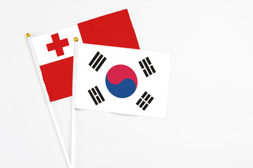 South Korea and Tonga stick flags on white background. High quality fabric, miniature national flag. Peaceful global concept.White floor for copy space.