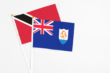 Fototapeta premium Anguilla and Trinidad And Tobago stick flags on white background. High quality fabric, miniature national flag. Peaceful global concept.White floor for copy space.