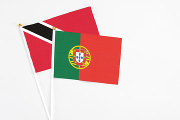 Portugal and Trinidad And Tobago stick flags on white background. High quality fabric, miniature national flag. Peaceful global concept.White floor for copy space.