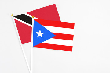 Puerto Rico and Trinidad And Tobago stick flags on white background. High quality fabric, miniature national flag. Peaceful global concept.White floor for copy space.