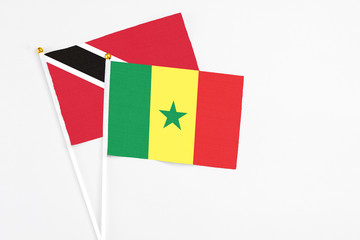 Senegal and Trinidad And Tobago stick flags on white background. High quality fabric, miniature national flag. Peaceful global concept.White floor for copy space.