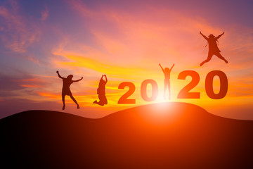Silhouette jumping people on mountain with twilight sky in sunrise or sunset celebrate new year 2020