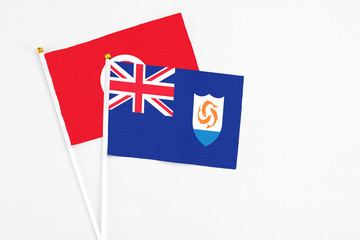 Fototapeta premium Anguilla and Tunisia stick flags on white background. High quality fabric, miniature national flag. Peaceful global concept.White floor for copy space.