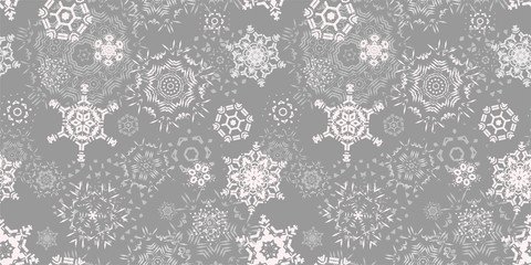 Elegant New year winter print. Christmas seamless pattern with snowflakes on a light gray (silver) background. Falling snow. Vector.