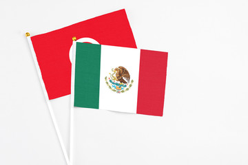 Mexico and Tunisia stick flags on white background. High quality fabric, miniature national flag. Peaceful global concept.White floor for copy space.