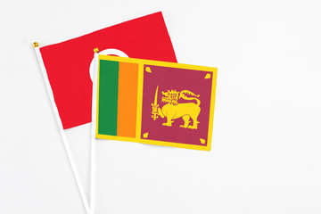 Sri Lanka and Tunisia stick flags on white background. High quality fabric, miniature national flag. Peaceful global concept.White floor for copy space.