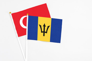 Barbados and Turkey stick flags on white background. High quality fabric, miniature national flag. Peaceful global concept.White floor for copy space.