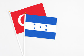 Honduras and Turkey stick flags on white background. High quality fabric, miniature national flag. Peaceful global concept.White floor for copy space.