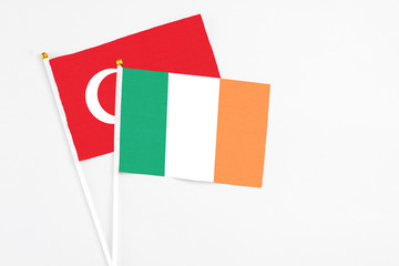 Ireland and Turkey stick flags on white background. High quality fabric, miniature national flag. Peaceful global concept.White floor for copy space.