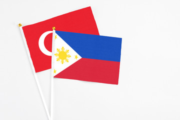 Philippines and Turkey stick flags on white background. High quality fabric, miniature national flag. Peaceful global concept.White floor for copy space.
