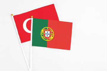 Portugal and Turkey stick flags on white background. High quality fabric, miniature national flag. Peaceful global concept.White floor for copy space.