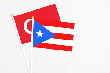 Puerto Rico and Turkey stick flags on white background. High quality fabric, miniature national flag. Peaceful global concept.White floor for copy space.