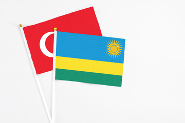 Rwanda and Turkey stick flags on white background. High quality fabric, miniature national flag. Peaceful global concept.White floor for copy space.