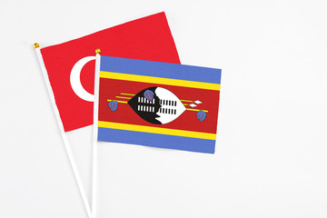 Swaziland and Turkey stick flags on white background. High quality fabric, miniature national flag. Peaceful global concept.White floor for copy space.