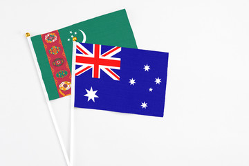 Fototapeta premium Australia and Turkmenistan stick flags on white background. High quality fabric, miniature national flag. Peaceful global concept.White floor for copy space.