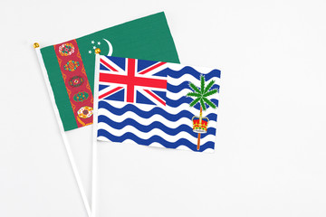 Fototapeta premium British Indian Ocean Territory and Turkmenistan stick flags on white background. High quality fabric, miniature national flag. Peaceful global concept.White floor for copy space.