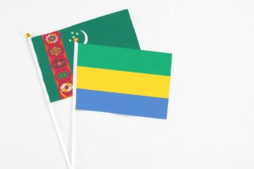 Gabon and Turkmenistan stick flags on white background. High quality fabric, miniature national...