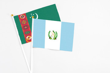 Guatemala and Turkmenistan stick flags on white background. High quality fabric, miniature national flag. Peaceful global concept.White floor for copy space.