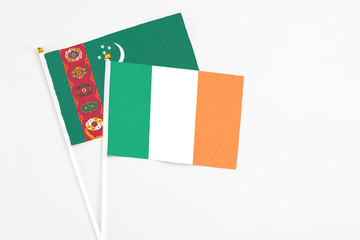 Ireland and Turkmenistan stick flags on white background. High quality fabric, miniature national flag. Peaceful global concept.White floor for copy space.