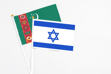 Israel and Turkmenistan stick flags on white background. High quality fabric, miniature national flag. Peaceful global concept.White floor for copy space.