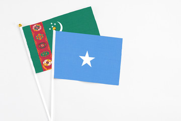 Somalia and Turkmenistan stick flags on white background. High quality fabric, miniature national flag. Peaceful global concept.White floor for copy space.