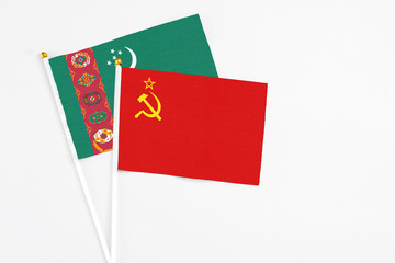 Fototapeta premium Soviet Union and Turkmenistan stick flags on white background. High quality fabric, miniature national flag. Peaceful global concept.White floor for copy space.