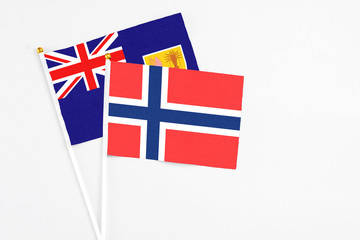 Fototapeta premium Bouvet Islands and Turks And Caicos Islands stick flags on white background. High quality fabric, miniature national flag. Peaceful global concept.White floor for copy space.