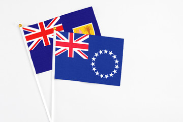 Cook Islands and Turks And Caicos Islands stick flags on white background. High quality fabric, miniature national flag. Peaceful global concept.White floor for copy space.