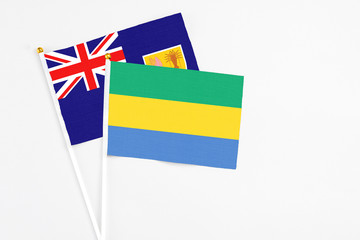 Gabon and Turks And Caicos Islands stick flags on white background. High quality fabric, miniature national flag. Peaceful global concept.White floor for copy space.