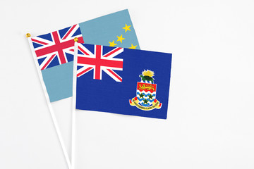 Fototapeta premium Cayman Islands and Tuvalu stick flags on white background. High quality fabric, miniature national flag. Peaceful global concept.White floor for copy space.