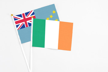 Ireland and Tuvalu stick flags on white background. High quality fabric, miniature national flag. Peaceful global concept.White floor for copy space.