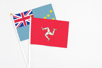 Isle Of Man and Tuvalu stick flags on white background. High quality fabric, miniature national flag. Peaceful global concept.White floor for copy space.