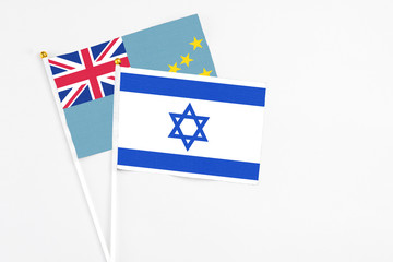 Fototapeta premium Israel and Tuvalu stick flags on white background. High quality fabric, miniature national flag. Peaceful global concept.White floor for copy space.