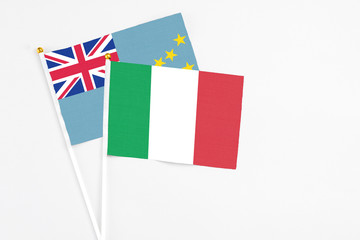 Italy and Tuvalu stick flags on white background. High quality fabric, miniature national flag. Peaceful global concept.White floor for copy space.