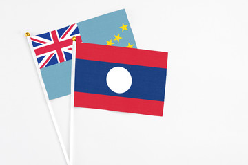 Laos and Tuvalu stick flags on white background. High quality fabric, miniature national flag. Peaceful global concept.White floor for copy space.