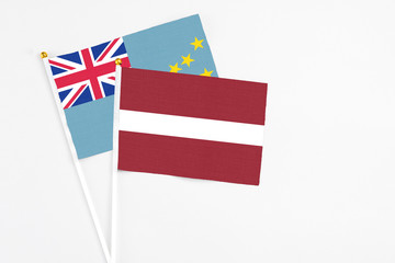 Obraz premium Latvia and Tuvalu stick flags on white background. High quality fabric, miniature national flag. Peaceful global concept.White floor for copy space.