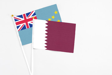 Qatar and Tuvalu stick flags on white background. High quality fabric, miniature national flag. Peaceful global concept.White floor for copy space.