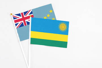 Rwanda and Tuvalu stick flags on white background. High quality fabric, miniature national flag. Peaceful global concept.White floor for copy space.
