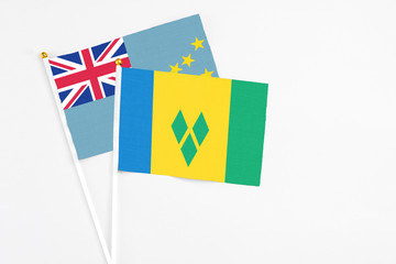 Saint Vincent And The Grenadines and Tuvalu stick flags on white background. High quality fabric, miniature national flag. Peaceful global concept.White floor for copy space.