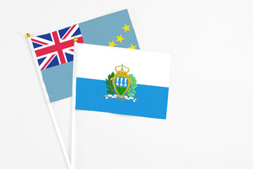 San Marino and Tuvalu stick flags on white background. High quality fabric, miniature national flag. Peaceful global concept.White floor for copy space.
