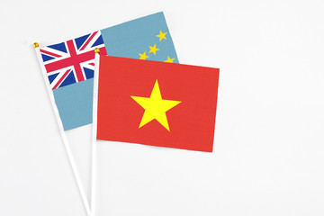 Vietnam and Tuvalu stick flags on white background. High quality fabric, miniature national flag. Peaceful global concept.White floor for copy space.