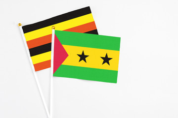 Sao Tome And Principe and Uganda stick flags on white background. High quality fabric, miniature national flag. Peaceful global concept.White floor for copy space.
