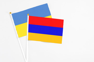 Armenia and Ukraine stick flags on white background. High quality fabric, miniature national flag. Peaceful global concept.White floor for copy space.