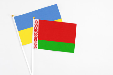 Belarus and Ukraine stick flags on white background. High quality fabric, miniature national flag. Peaceful global concept.White floor for copy space.