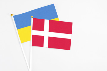 Denmark and Ukraine stick flags on white background. High quality fabric, miniature national flag. Peaceful global concept.White floor for copy space.