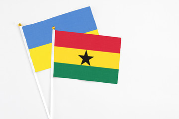 Ghana and Ukraine stick flags on white background. High quality fabric, miniature national flag. Peaceful global concept.White floor for copy space.
