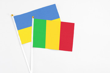 Mali and Ukraine stick flags on white background. High quality fabric, miniature national flag. Peaceful global concept.White floor for copy space.